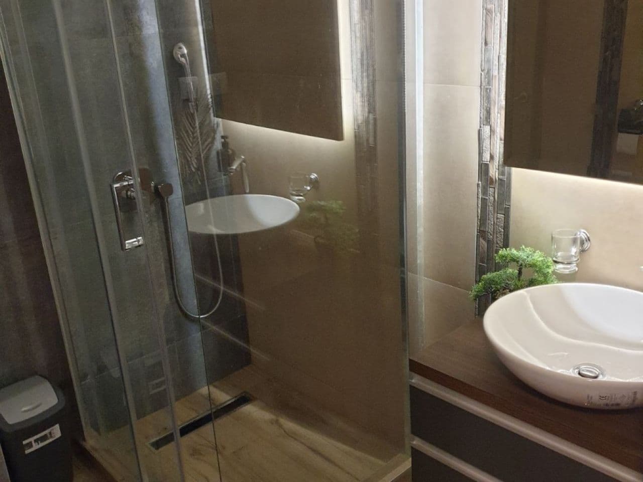 Kupatilo — staklena tuš kabina, lebdeći lavabo, ogledalo sa rasvetom
